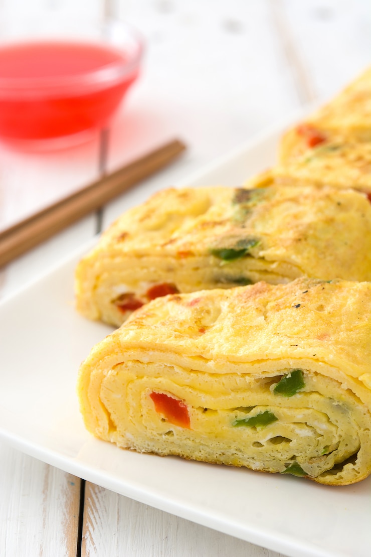 Photo 흰색 나무 테이블에 전통적인 tamagoyaki 일본 오믈렛.