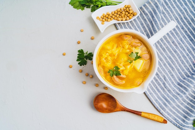 Traditional tasty pea soup with smoked sausage served in white bowl