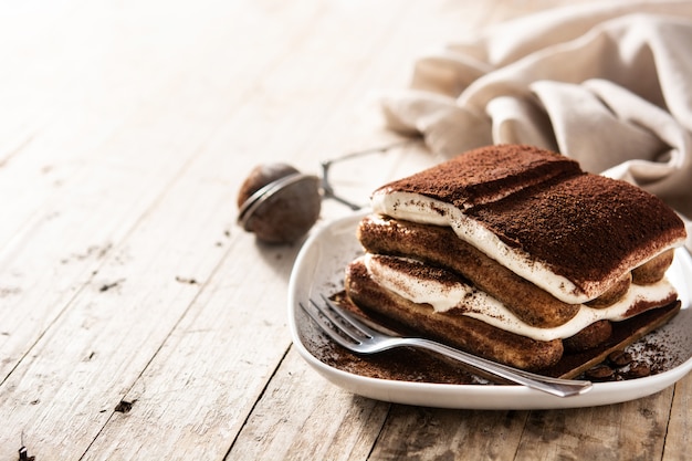 Traditional tiramisu cake on wooden table