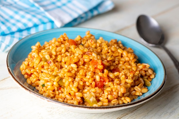 접시에 토마토 소스를 곁들인 전통 터키식 bulgur 필라프(터키어 이름, meyhane pilavi)