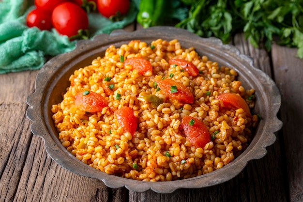 Traditional turkish bulgur pilaf with tomato sause in plate Turkish name meyhane pilavi