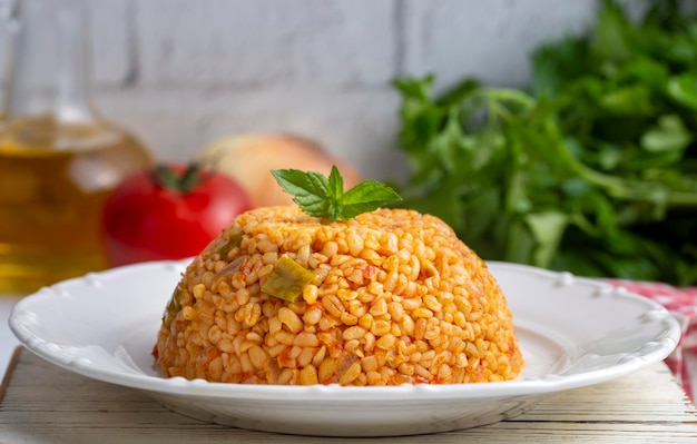 Traditional turkish bulgur pilaf with tomato sause in plate (Turkish name; meyhane pilavi)