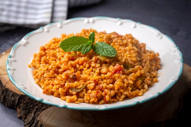 Traditional turkish bulgur pilaf with tomato sause in plate (Turkish name; meyhane pilavi)