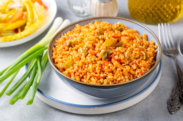 접시에 토마토 소스를 곁들인 전통 터키식 bulgur 필라프(터키어 이름, meyhane pilavi)