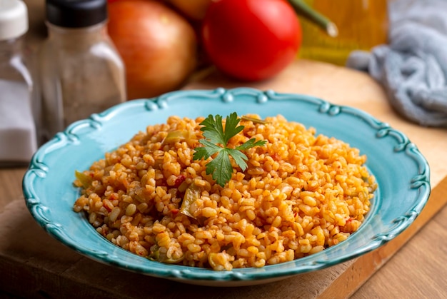 Pilaf turco tradizionale del bulgur con salsa di pomodoro nel piatto nome turco meyhane pilavi