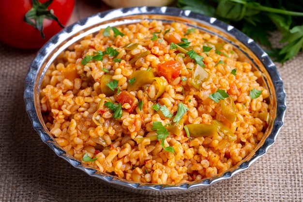 Traditional turkish bulgur pilaf with tomato sause in plate Turkish name meyhane pilavi