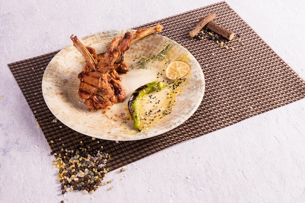 Traditional Turkish chicken kebab on white plate with lemon slice and pepper
