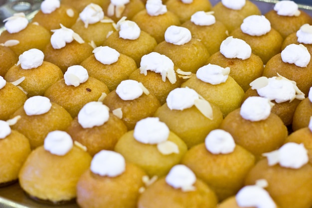 Traditional Turkish dessert Shekerpare with whipped cream. Sliced portioned at the hotel