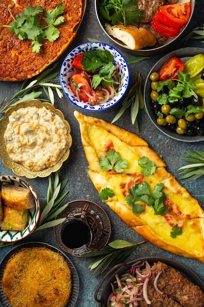 Photo traditional turkish food assorted dishes and mezze appetizers on rustic background from above pide lahmacun meat kebab turkish meatballs sweet baklava and kunefe middle east cuisine top view