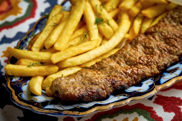 Traditional Turkish lula kebab made of minced meat served on a plate with french fries