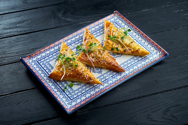 Traditional Turkish meat patty - burek served on a blue plate against a dark background.