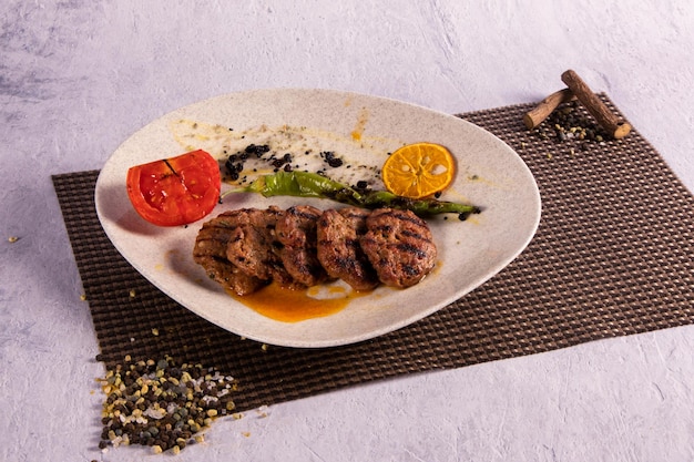 Traditional Turkish meatballs on white plate with tomato