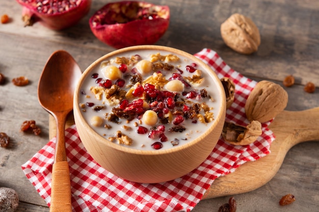 Traditional Turkish Noah's pudding in bowl on wooden table