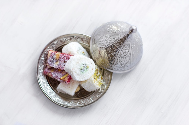 Photo traditional turkish sweets lukum on a silver saucer with lid