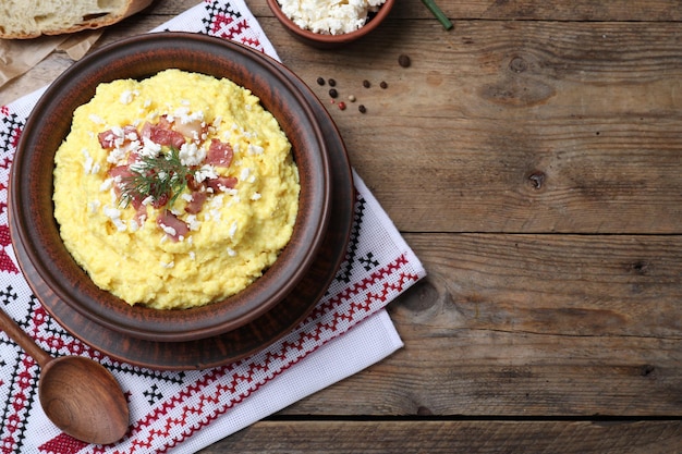 Photo traditional ukrainian banosh served with brynza and pork cracklings on wooden table flat lay space for text