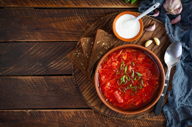 Borscht ucraino tradizionale con cipolla verde e panna acida deliziosa zuppa di barbabietole in una ciotola con pane di segale vista dall'alto