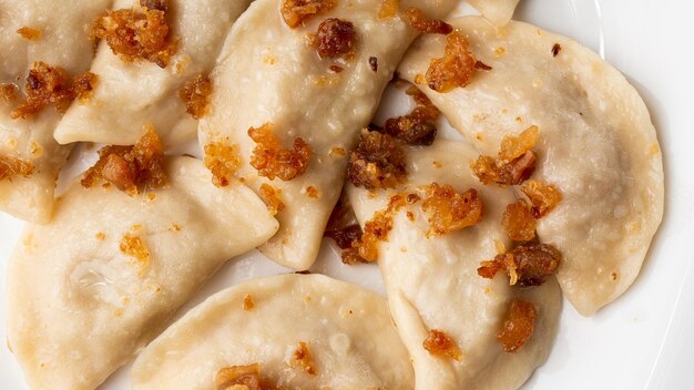 Traditional ukrainian dish vareniki served in a bowl with greaves and sour cream Close up view of traditional Ukrainian food