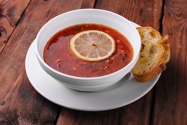 Traditional Ukrainian meat soup Solyanka in bowl