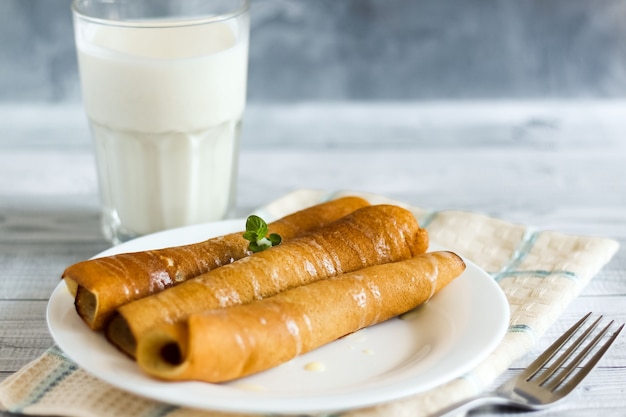 Traditional Ukrainian pancakes with condensed Milk and glass of milk or kefir