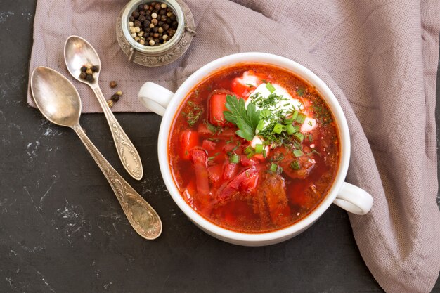 Traditional Ukrainian Russian soup (borscht) from beet with greens and sour cream.