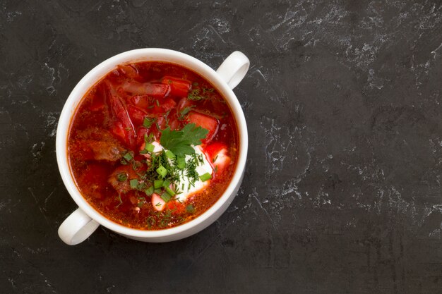 Traditional Ukrainian Russian soup (borscht) from beet with greens and sour cream.