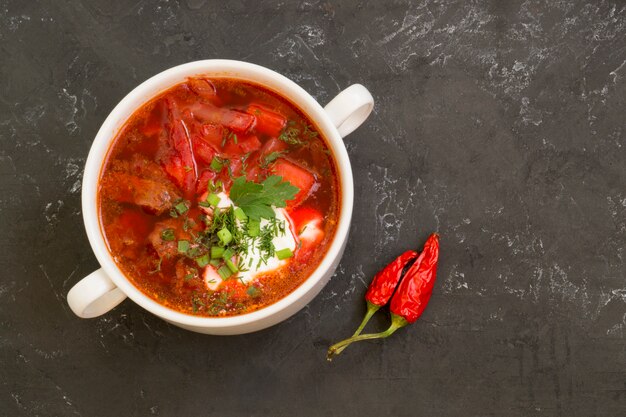 Traditional Ukrainian Russian soup (borscht) from beet with greens and sour cream.