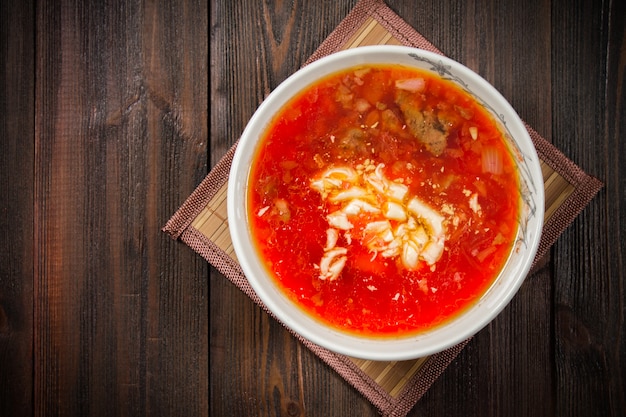 Traditional Ukrainian Russian vegetable borscht on the white wooden background. Top view