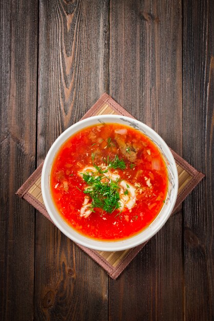 Traditional Ukrainian Russian vegetable borscht on the white wooden background. Top view