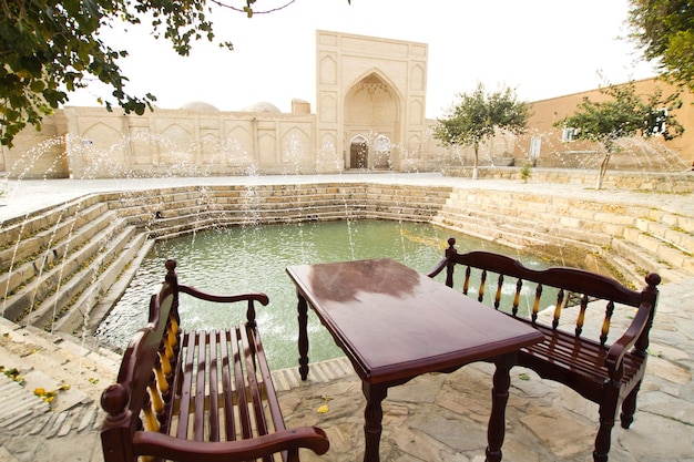 Traditional Uzbek courtyard with pond and fountain in Old Bukhara town, Uzbekistan