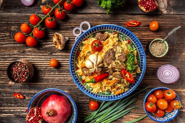 Traditional uzbek meal called pilaf. Rice with meat, carrot and onion in plate with oriental ornament, Uzbek oriental cuisine. top view.