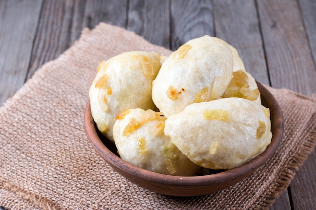 Traditional vareniki in a bowl on a wooden table