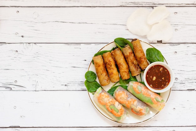 Traditional Vietnamese rolls and rice chips on a wooden board