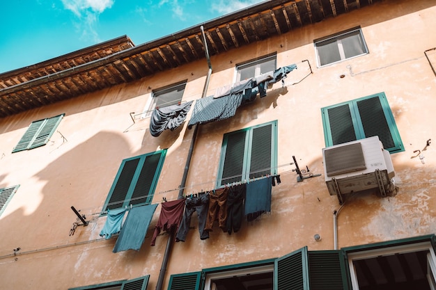 Traditional way of drying laundry in old facade build Pisa Italy