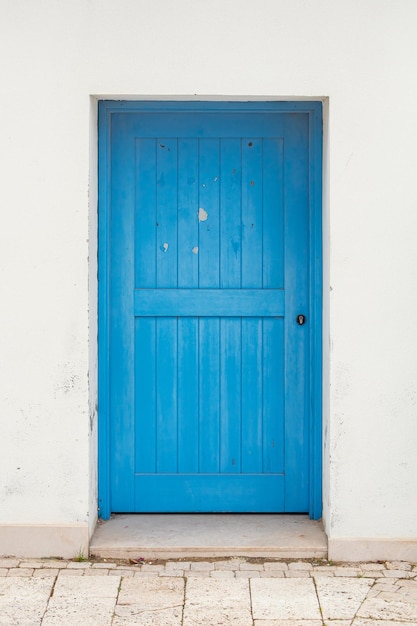 Traditional white Greek house facade with blue door