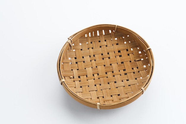 Traditional wicker plate made of bamboo isolated on a white background. Copy space.