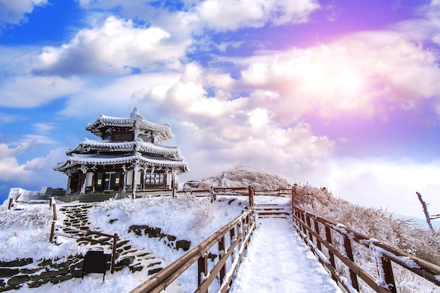 Traditional windmill against sky during winter