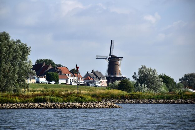 Photo traditional windmill by trees against sky