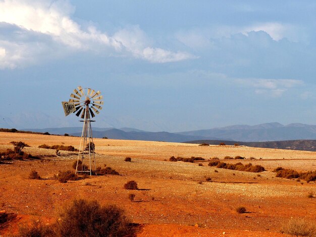 Traditional windmill on desert against sky