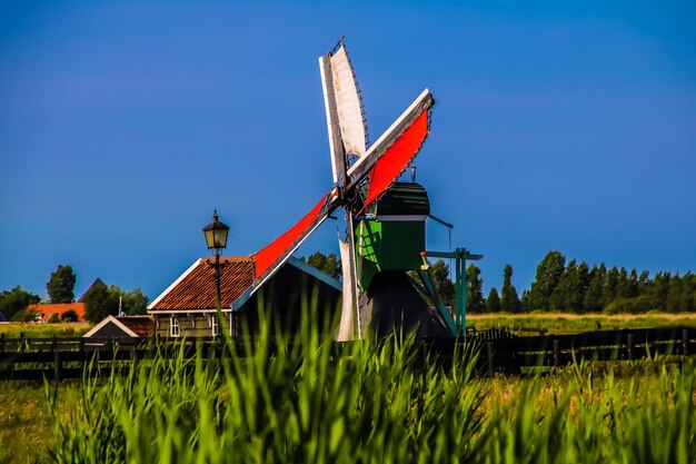 Традиционная ветряная мельница на поле на фоне ясного неба