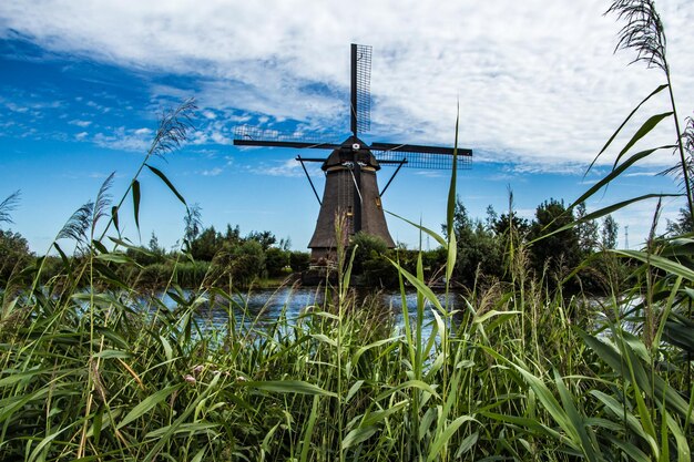 Traditional windmill on field against sky