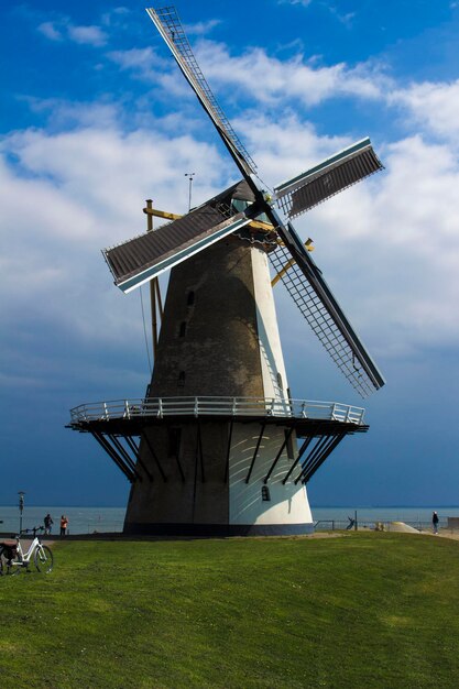 Traditional windmill on field against sky