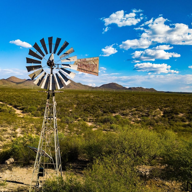 Traditional windmill on land against blue sky