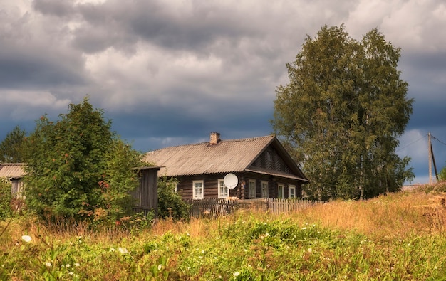 Photo traditional wooden house in a russian village in the north in summer.