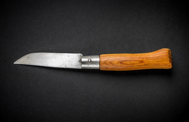 Traditional wooden pocket knife on black background