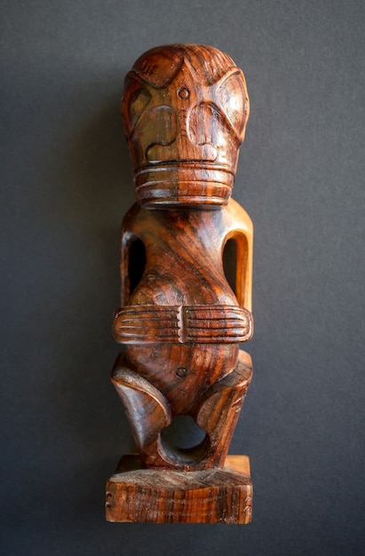 Photo traditional wooden polynesian tiki from marquesas islands. isolated on a dark background