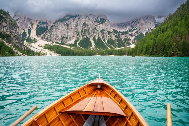 Photo traditional wooden rowing boat on scenic lago di braies in the dolomites south tyrol italy