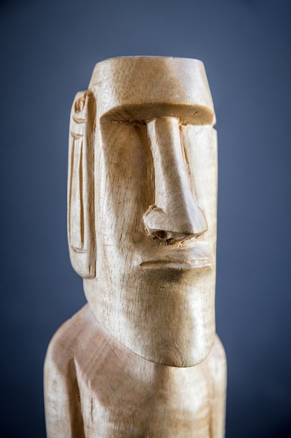 Traditional wooden statue of a moai from Easter Island. Dark background