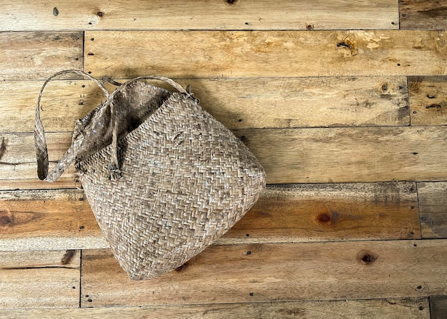 A traditional woven tote bag made from recycle materials on wooden floor