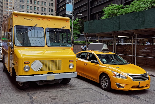 Фото Традиционное желтое такси и фургон на улице манхэттена. желтые такси — известная икона нью-йорка.