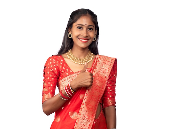 Traditional young smiling girl showing ok sign or thumbs up on a white background